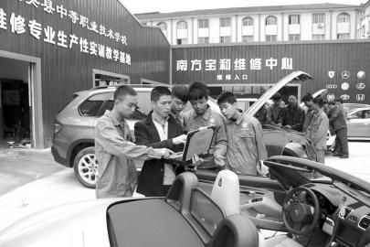 大英縣中等職業學校通過“引企入?！?，將企業維修中心建到了校園內，圖為企業專業技師向學生講解高檔轎車的保養維修技巧。